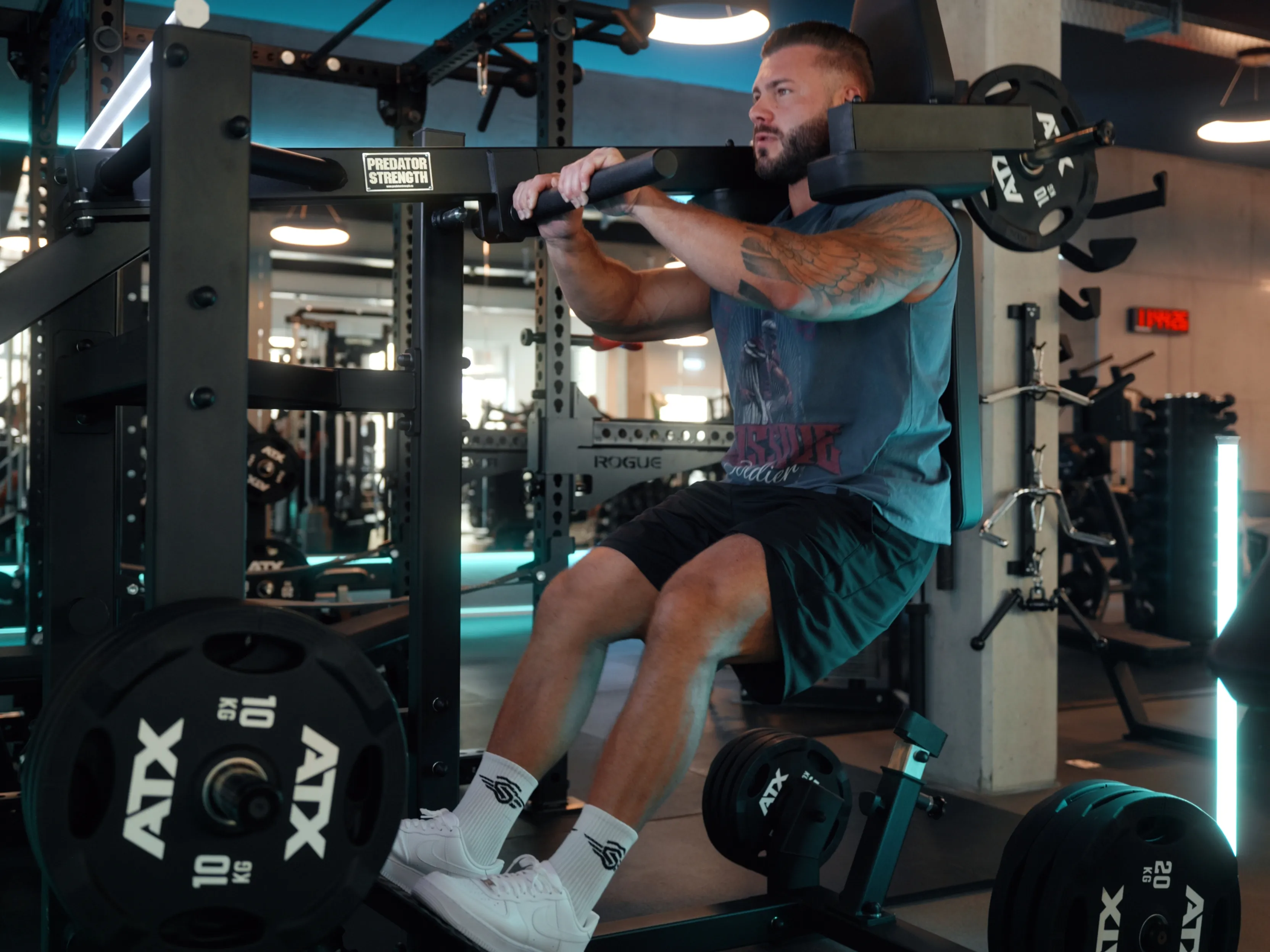 Mann trainiert mit Rückenmaschine und Gewichten in einem modernen Fitnessstudio.